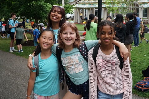 Four girls smiling at camera with arms around each other