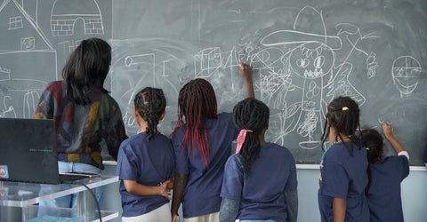 Girls colouring on a chalk board