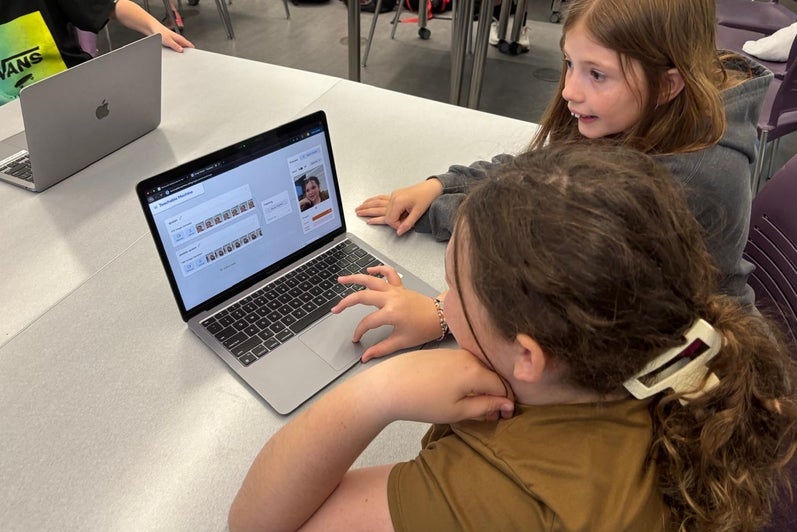 Students using a laptop to teach a machine learning algorithm how to recognize objects