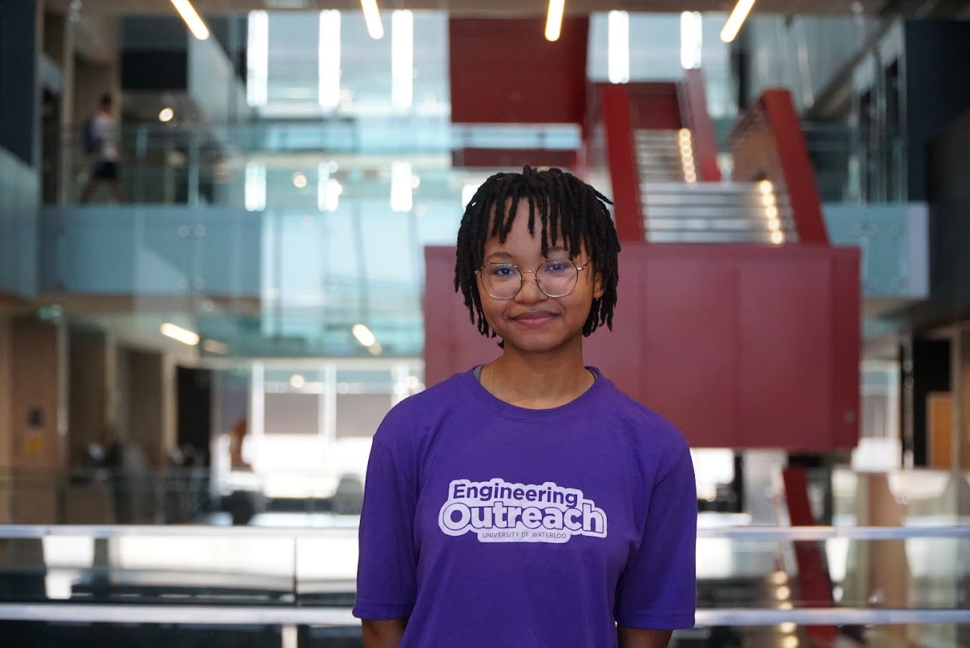 girl in purple with glasses smiling at camera