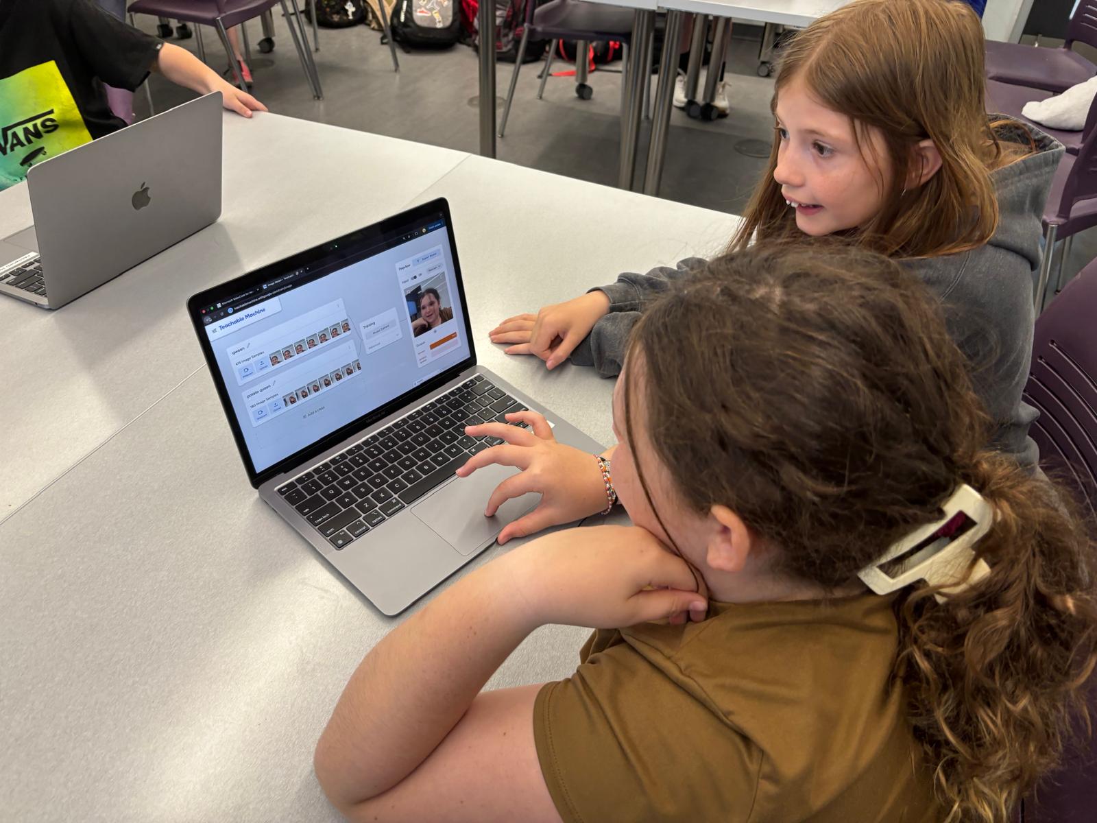 Students using a laptop to teach a machine learning algorithm how to recognize objects