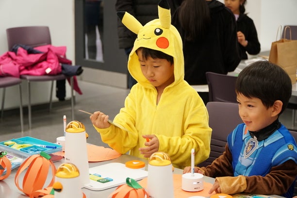 Two kids dress up for Halloween, experimenting with MatataStudio Coding