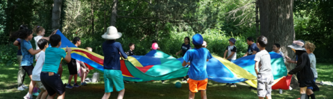 Campers playing a parachute games outdoors