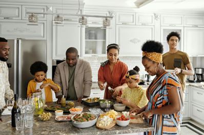 family around kitchen table filled with food