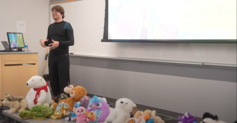 Daniel leading workshop with stuffies on table in front of him