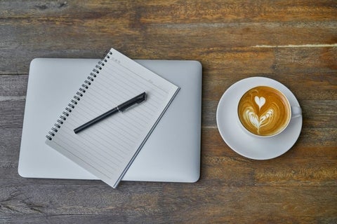 computer, notebook and coffee on table