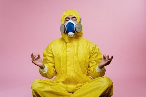Person in a yellow hazmat suit meditating
