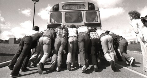 Engineers pushing a school bus. 