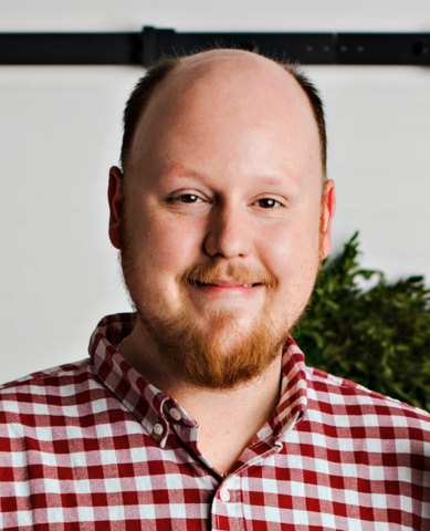 A white man smiles at the camera