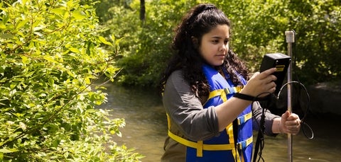 Student doing surveying work in river