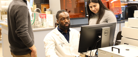 Grad working on computer in a lab