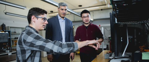 Man pointing at computer and others looking