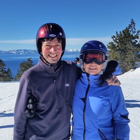 Mark with his partner, wearing skiing outfit, on the mountains