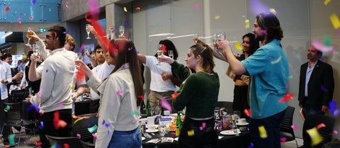 Students celebrating with confetti and raised glasses