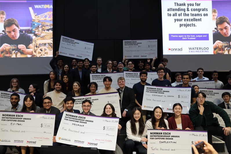 Group of students holding large cheques at pitch event