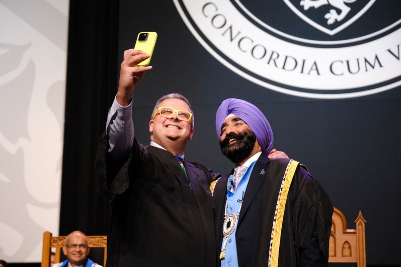 A man takes a selfie with the Chancellor on stage