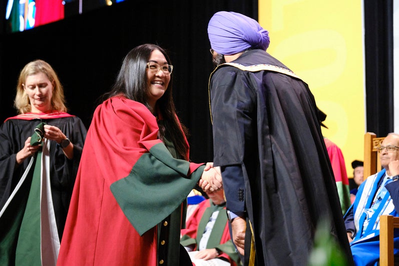 A graduate shakes the Chancellor's hand