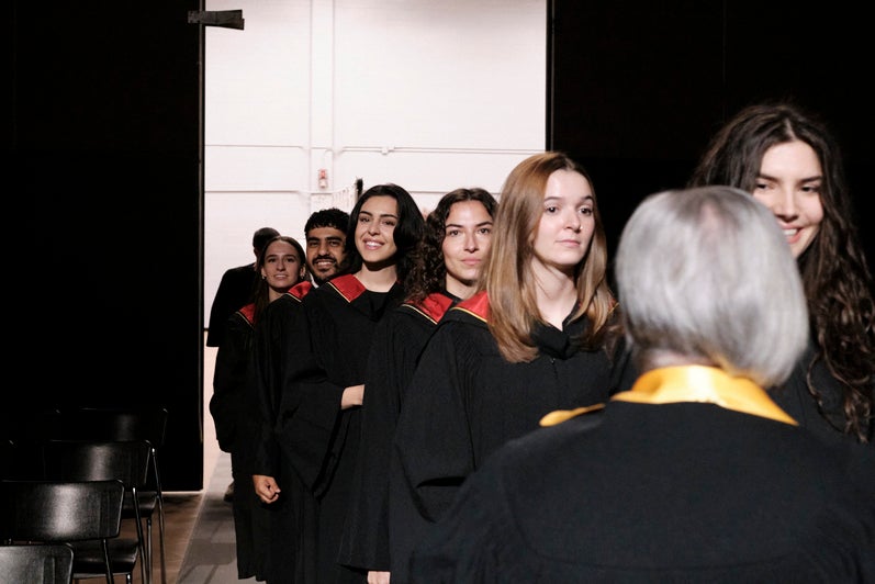 Graduates walk into their convocation ceremony, one by one.