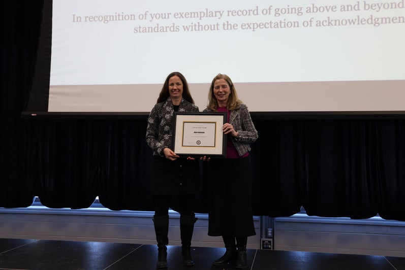 Two women pose with a certificate 