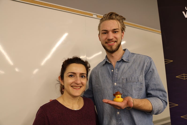 A woman and a young man pose beside a Waterloo Engineering sign; the man is holding a small rubber ducky.