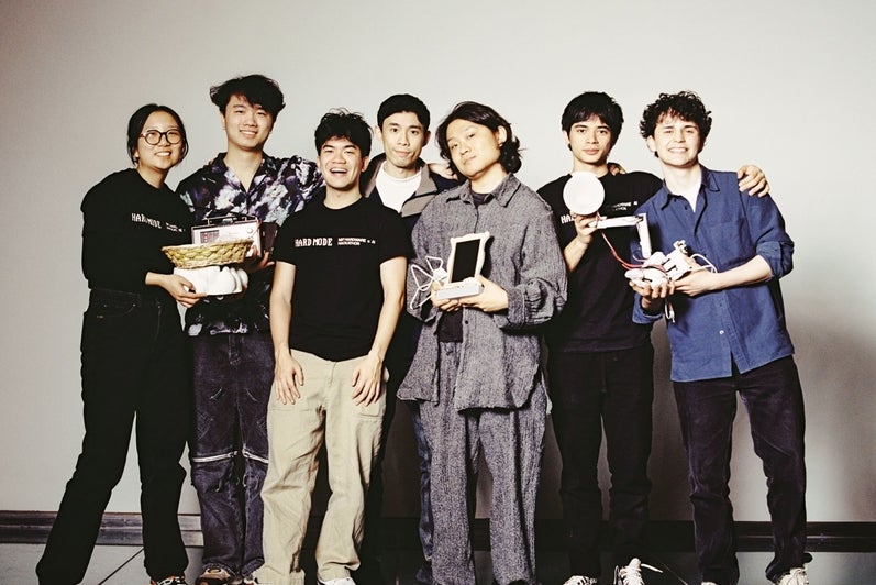 A group of students pose in front of a white background.