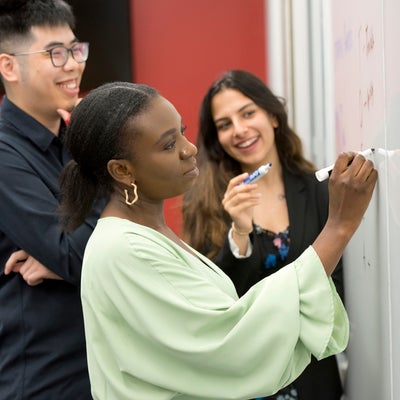 Group of students writing on a whiteboard