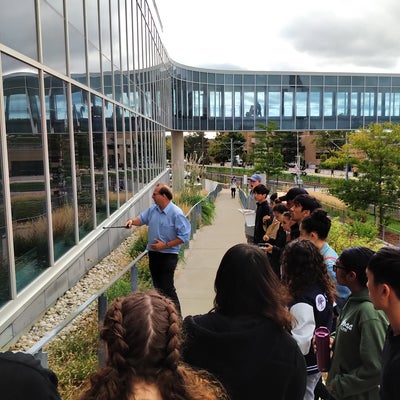 Professor teaching group of students outside of a building