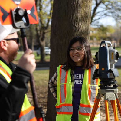 Student conducting surveying work outside