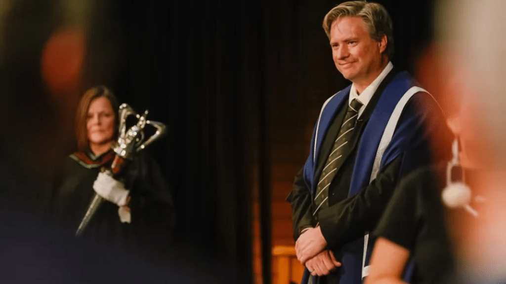 Bill Rosehart listens during his installation ceremony on stage