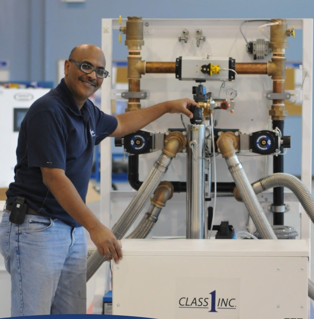 Osama Elgadi standing next to the Class 1 system machine