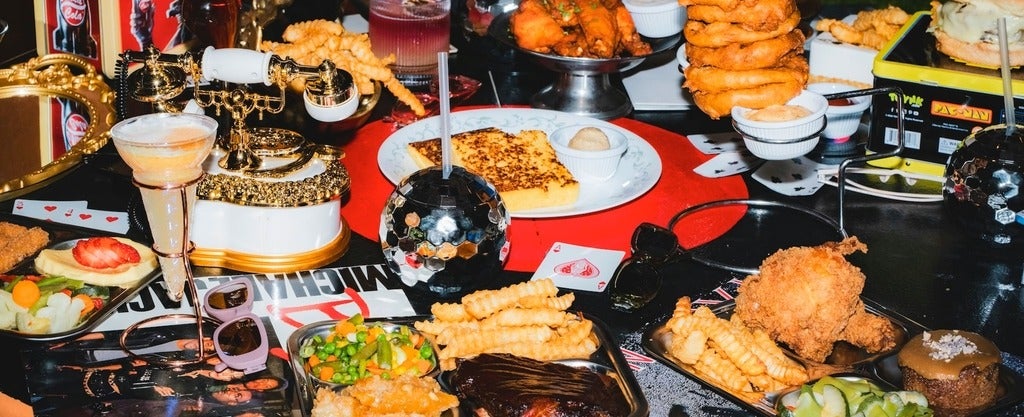 Retro Room image from Back Bay Social restaurant of a table filled with food, landline telephones and other retro items
