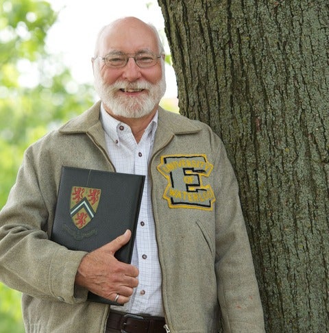 Bill Lennox (BASc '62) wearing Waterloo Engineering jacket and holding yearbook