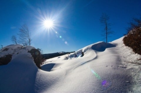 sun shining on snowy hill