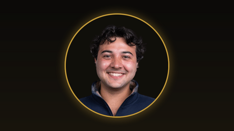A young man smiles at the camera.
