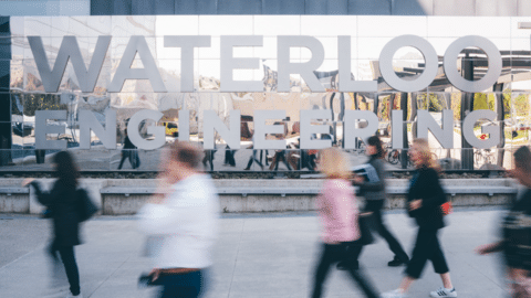 People walk by the Waterloo Engineering sign outside of Pearl Sullivan Engineering.