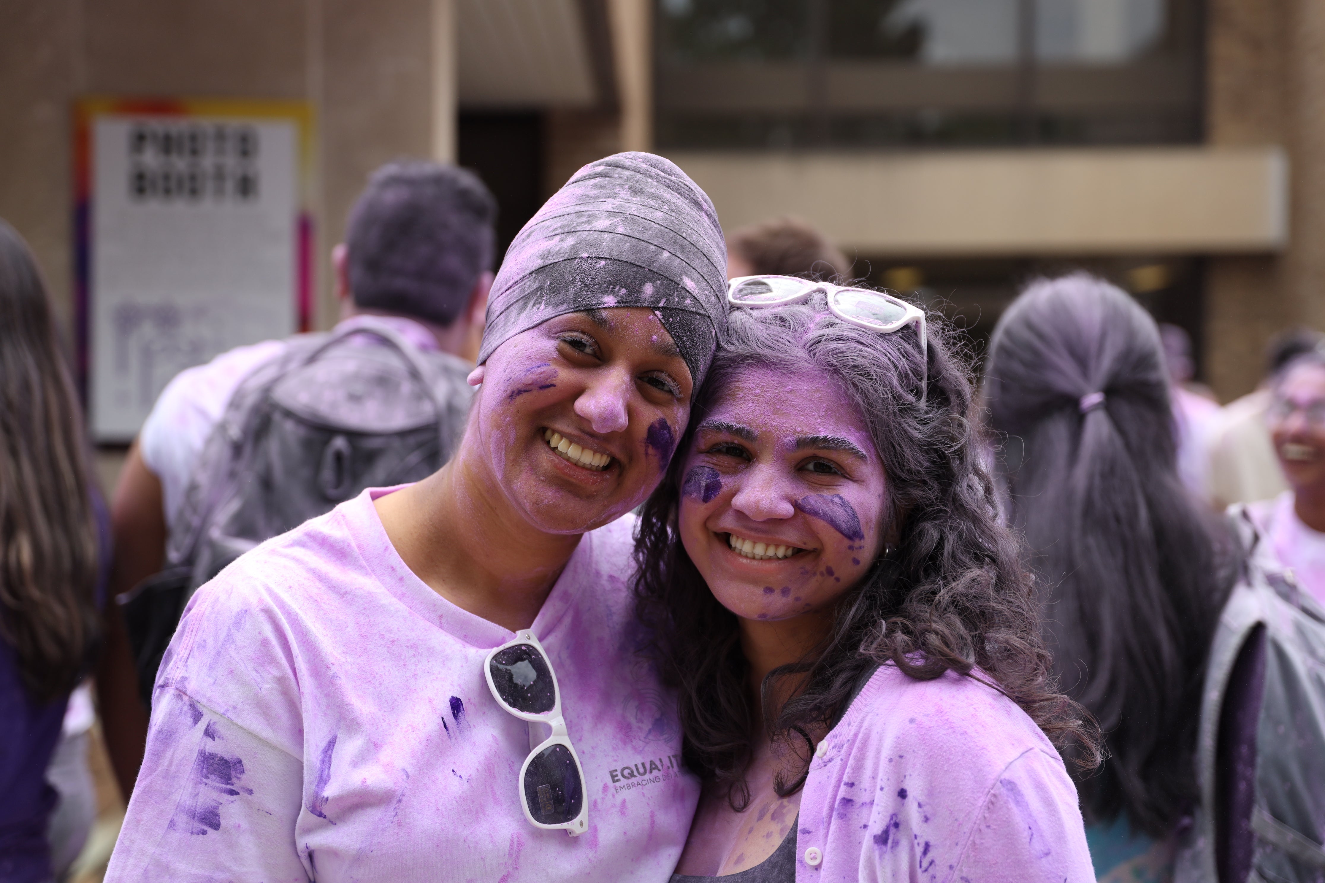 Students smiling covered in purple powder