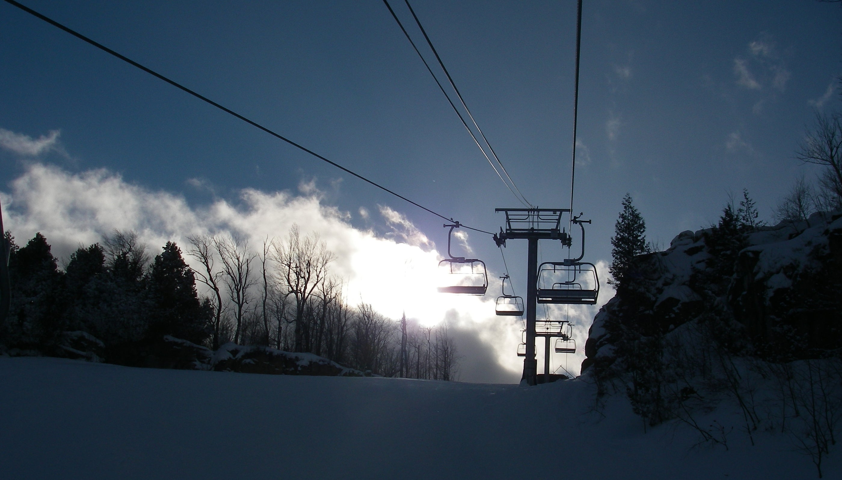 Ski lifts with sunshine behind them at Osler Bluff Ski Club