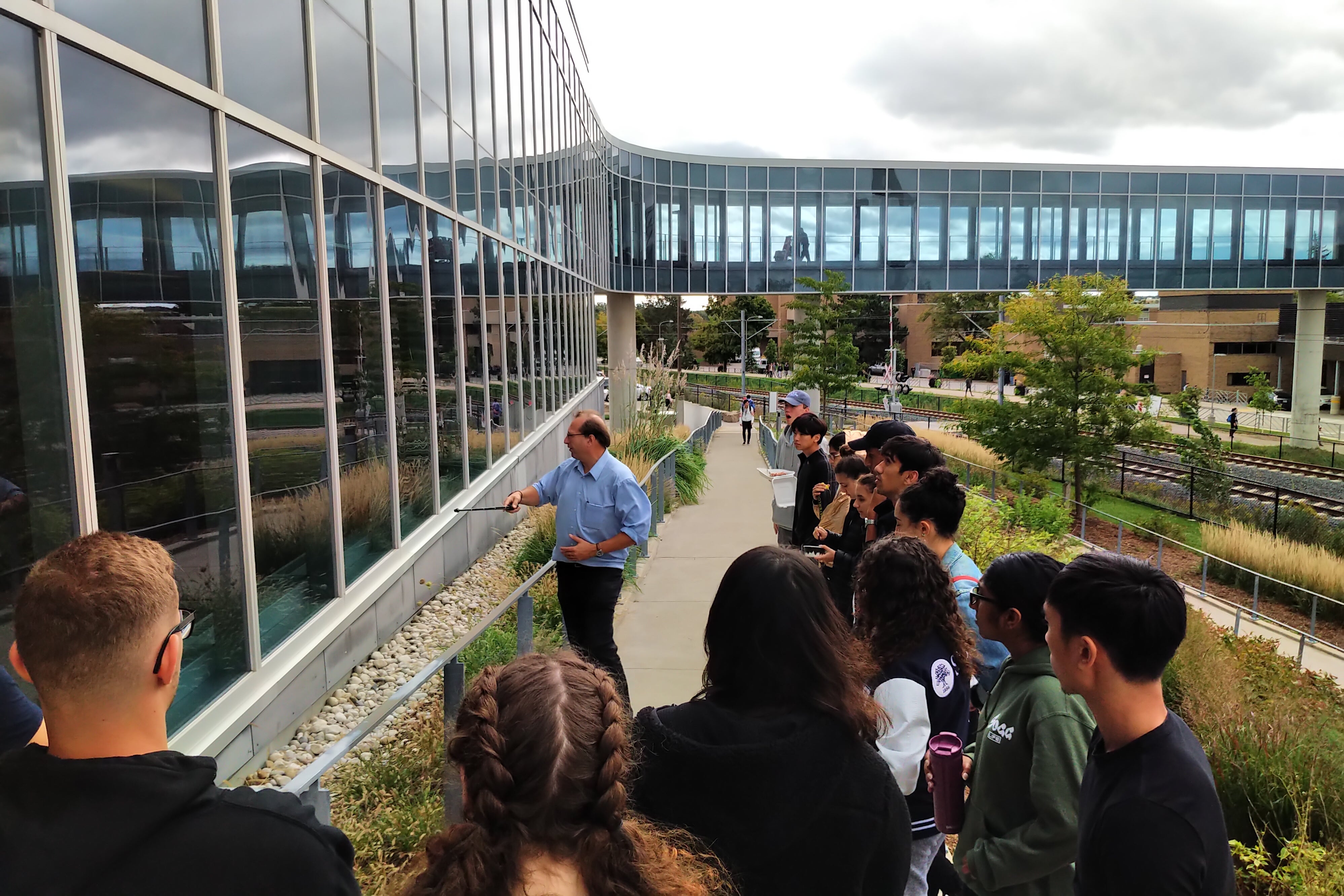 Professor teaching group of students outside of a building