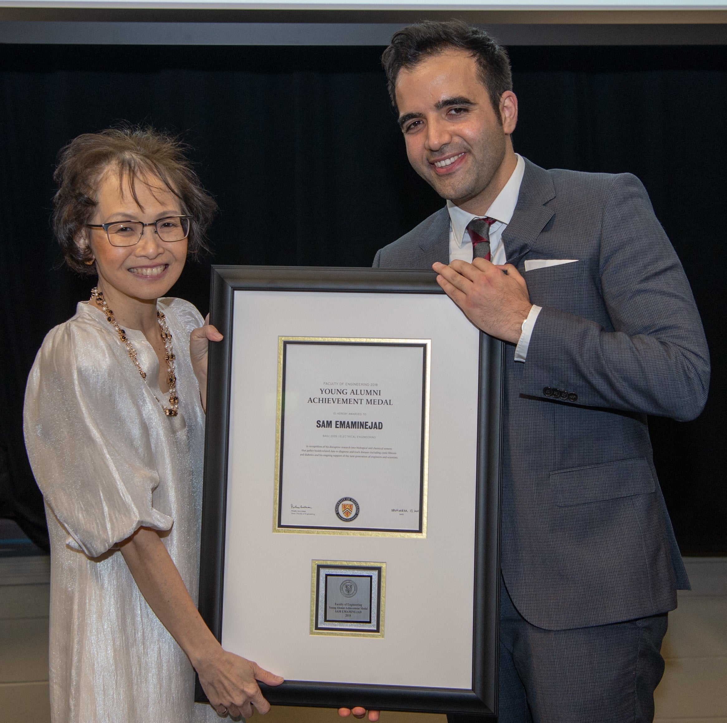Sam Emaminejad (right) poses with Dean Pearl Sullivan with his award for achievement by young alumni. by
