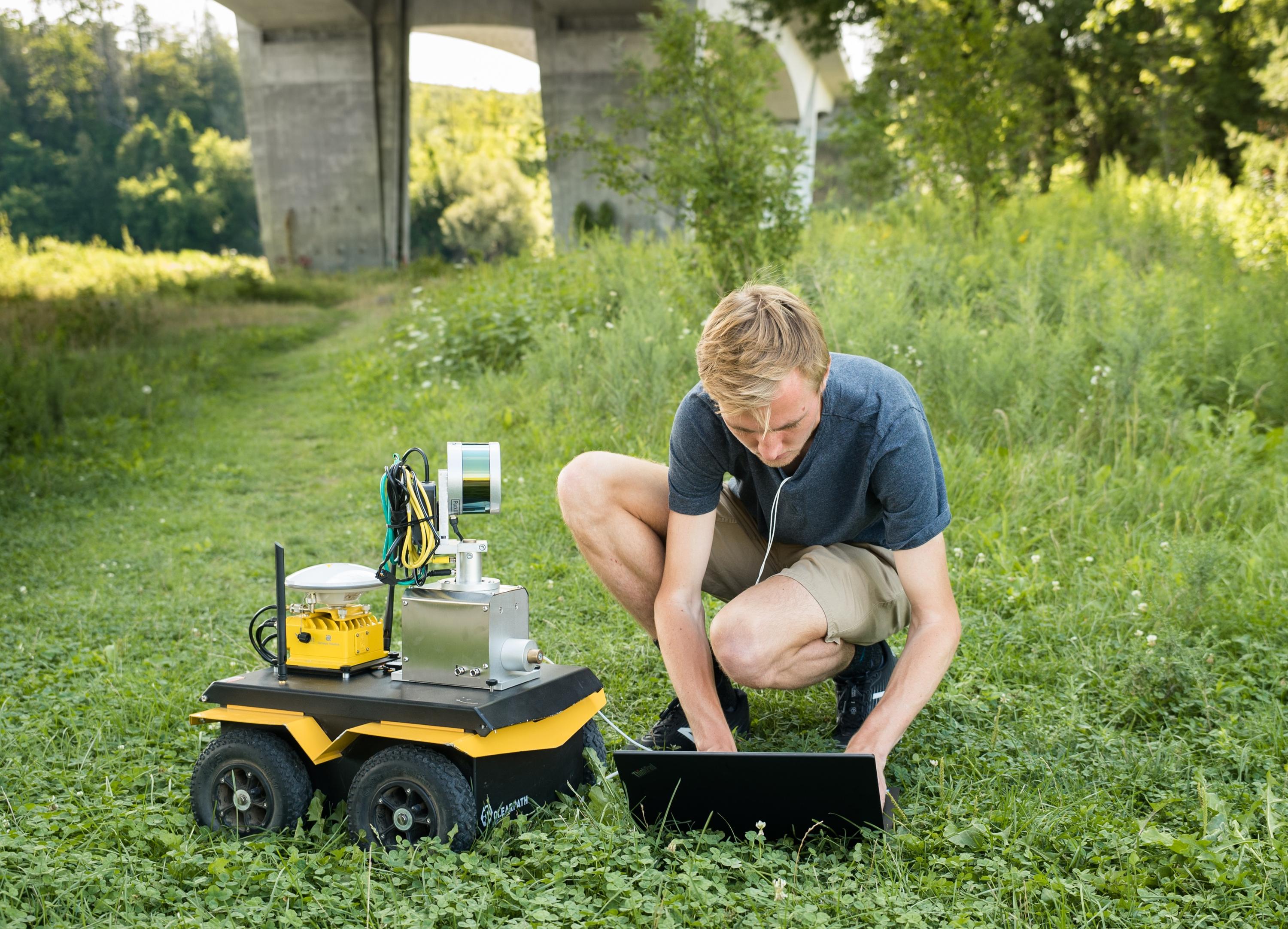 Stephen Phillips, a PhD student at the University of Waterloo, works with a robotic ground vehicle used in research on automating bridge inspections.