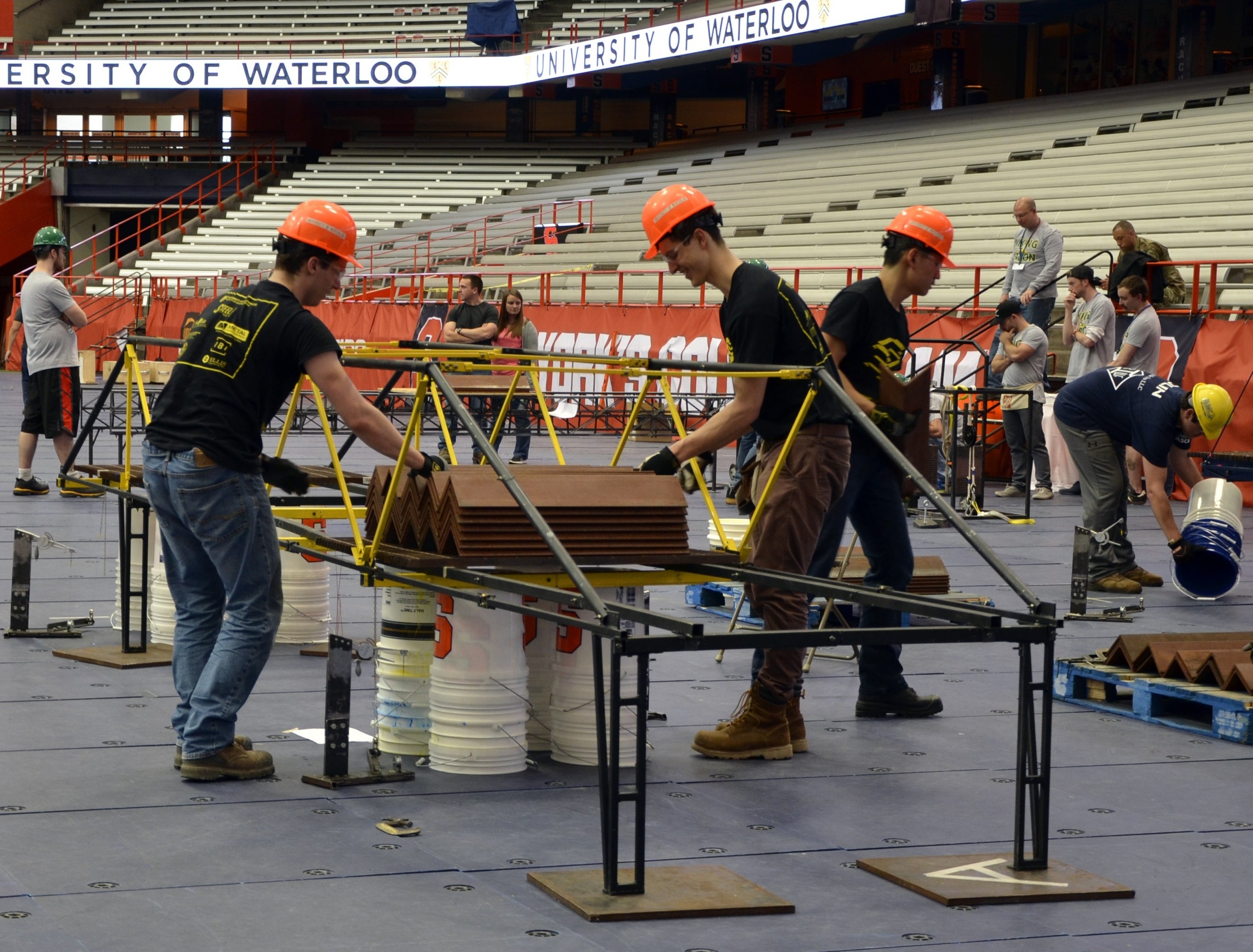 Members of the Waterloo Engineering steel bridge team in action at a competition at Syracuse University.