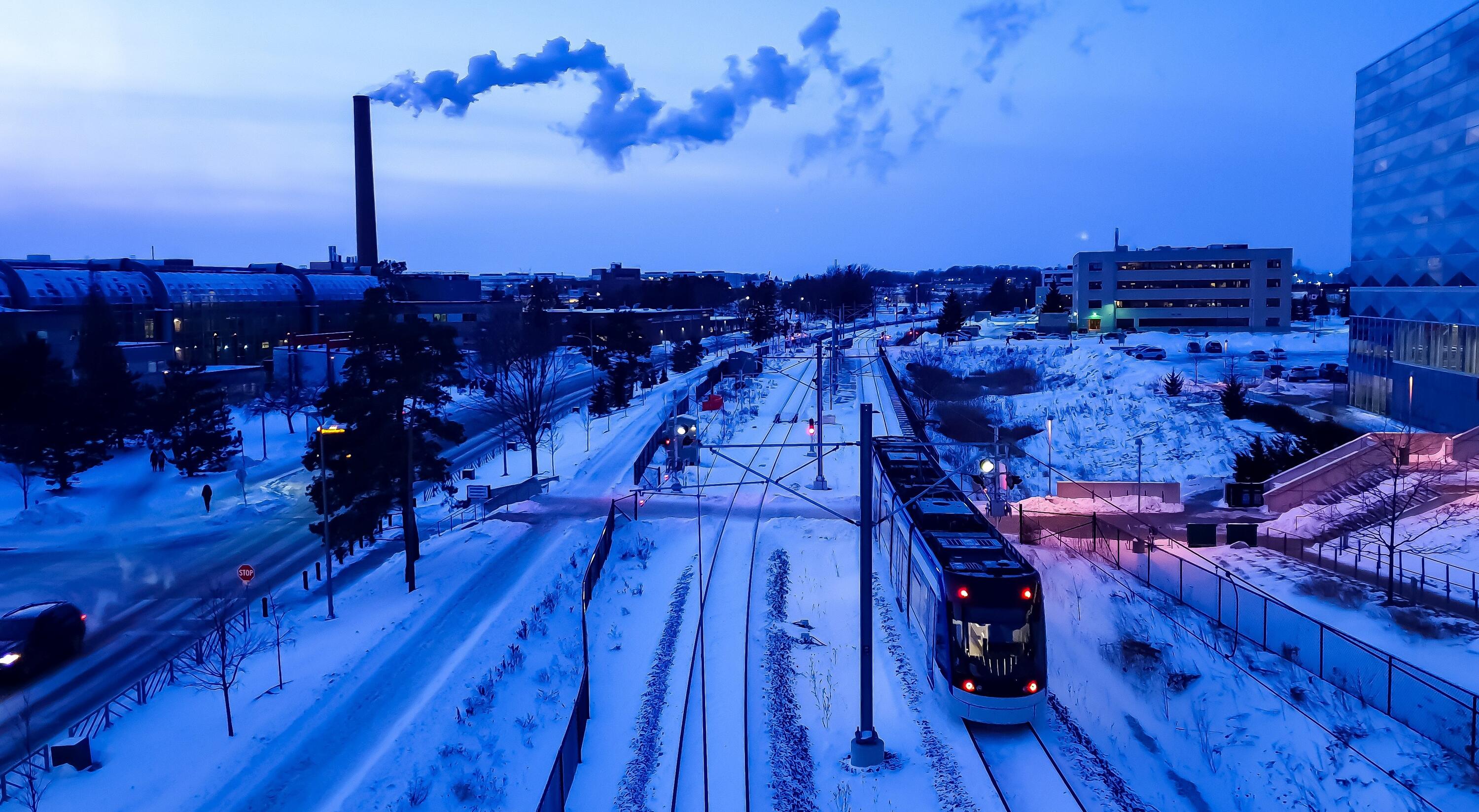 Photo of campus with LRT Train next to the Engineering 5 building in winter