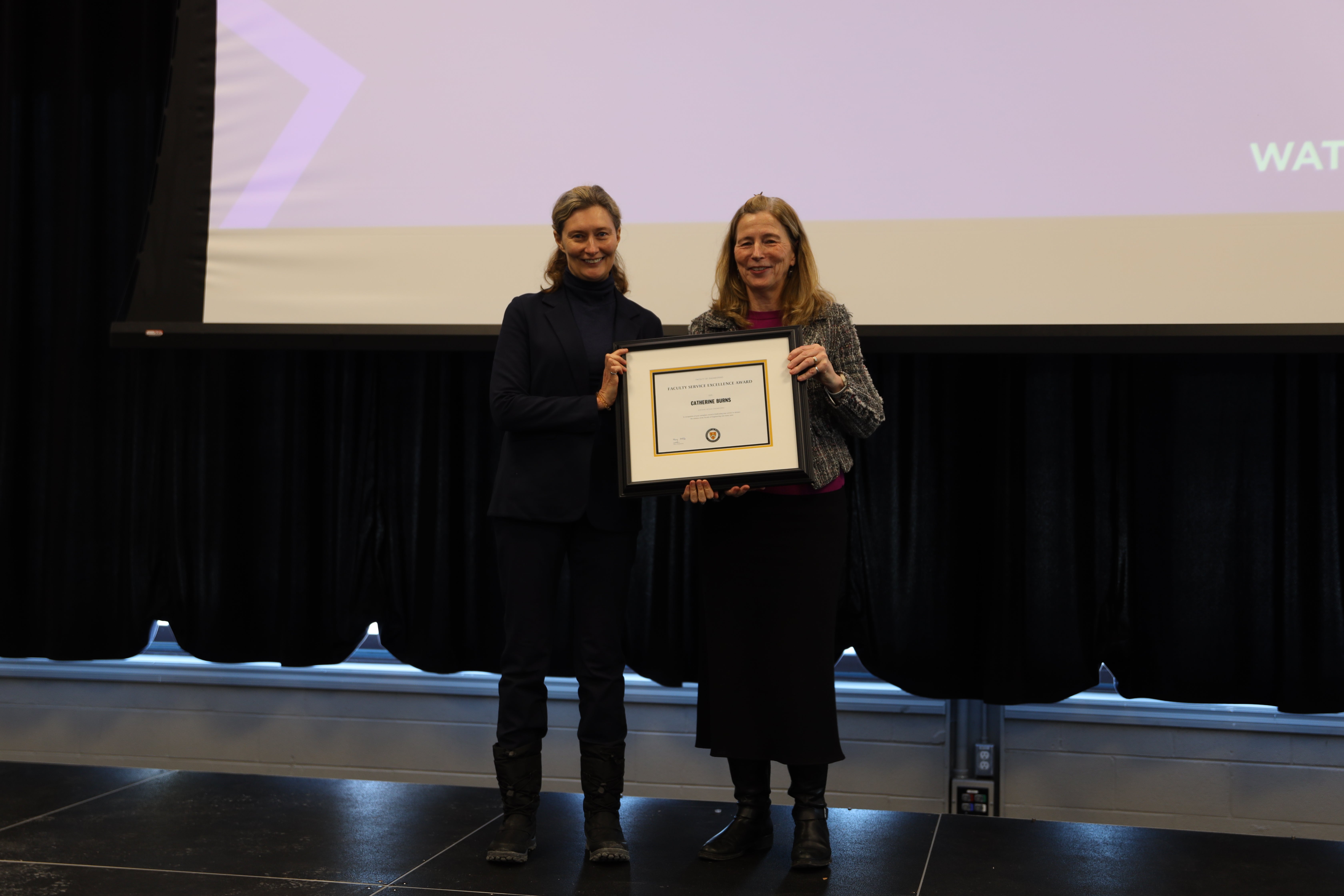 Two women pose with a certificate 