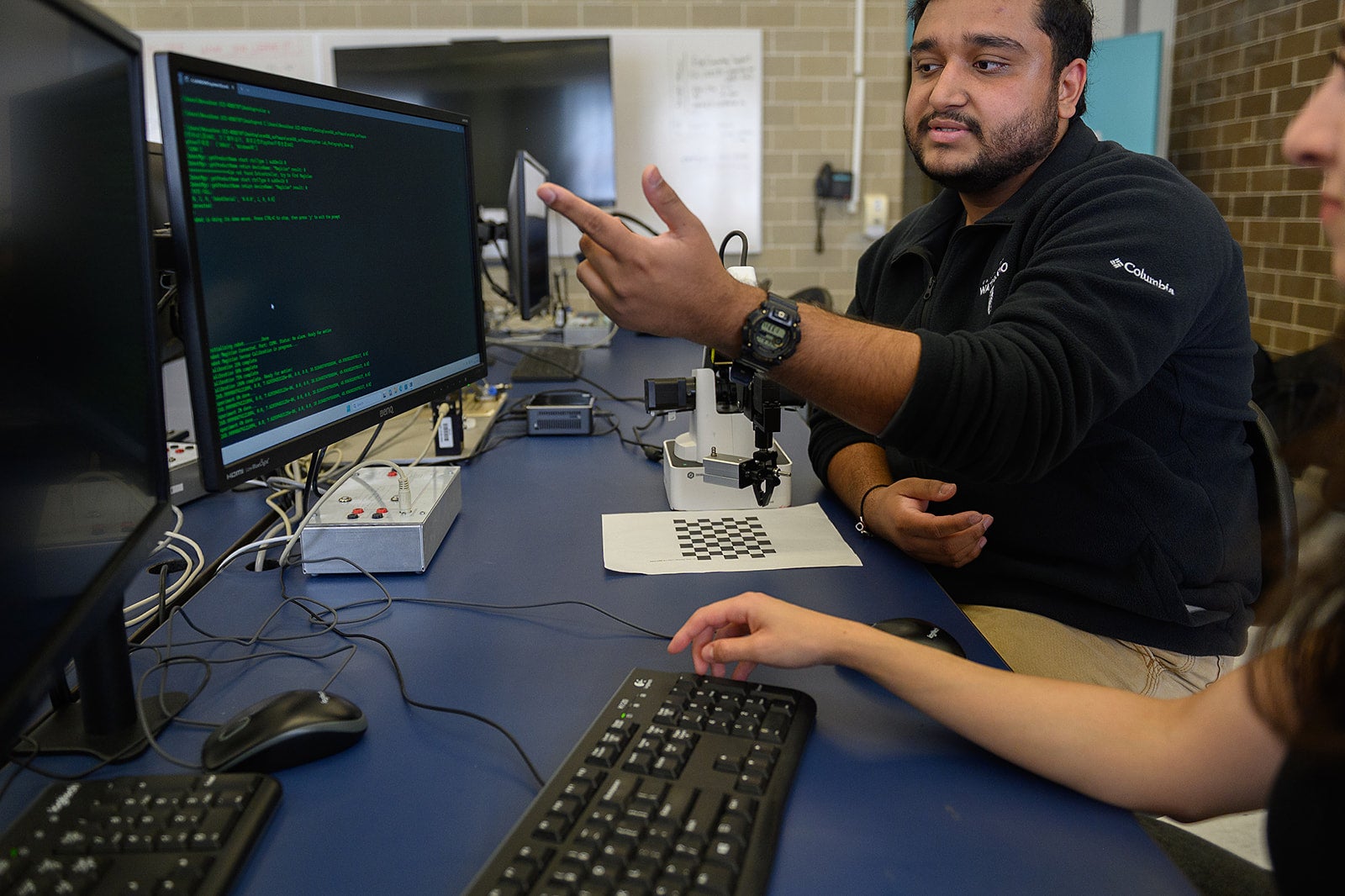 Students discussing code on computer
