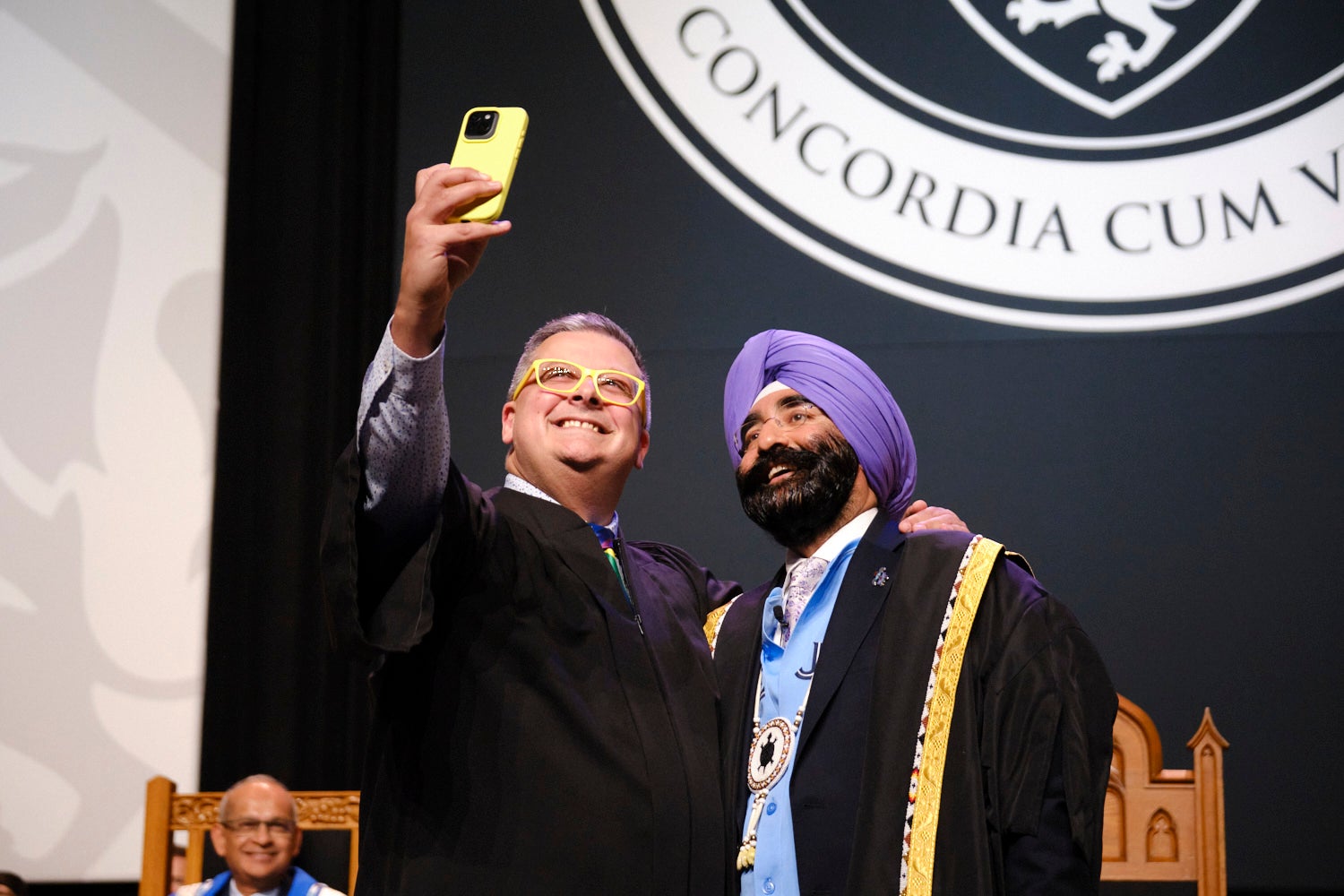 A man takes a selfie with the Chancellor on stage