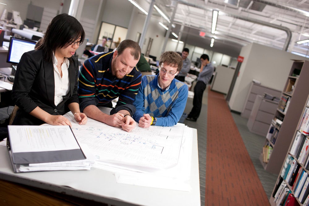 Professor and students working on a floorplan