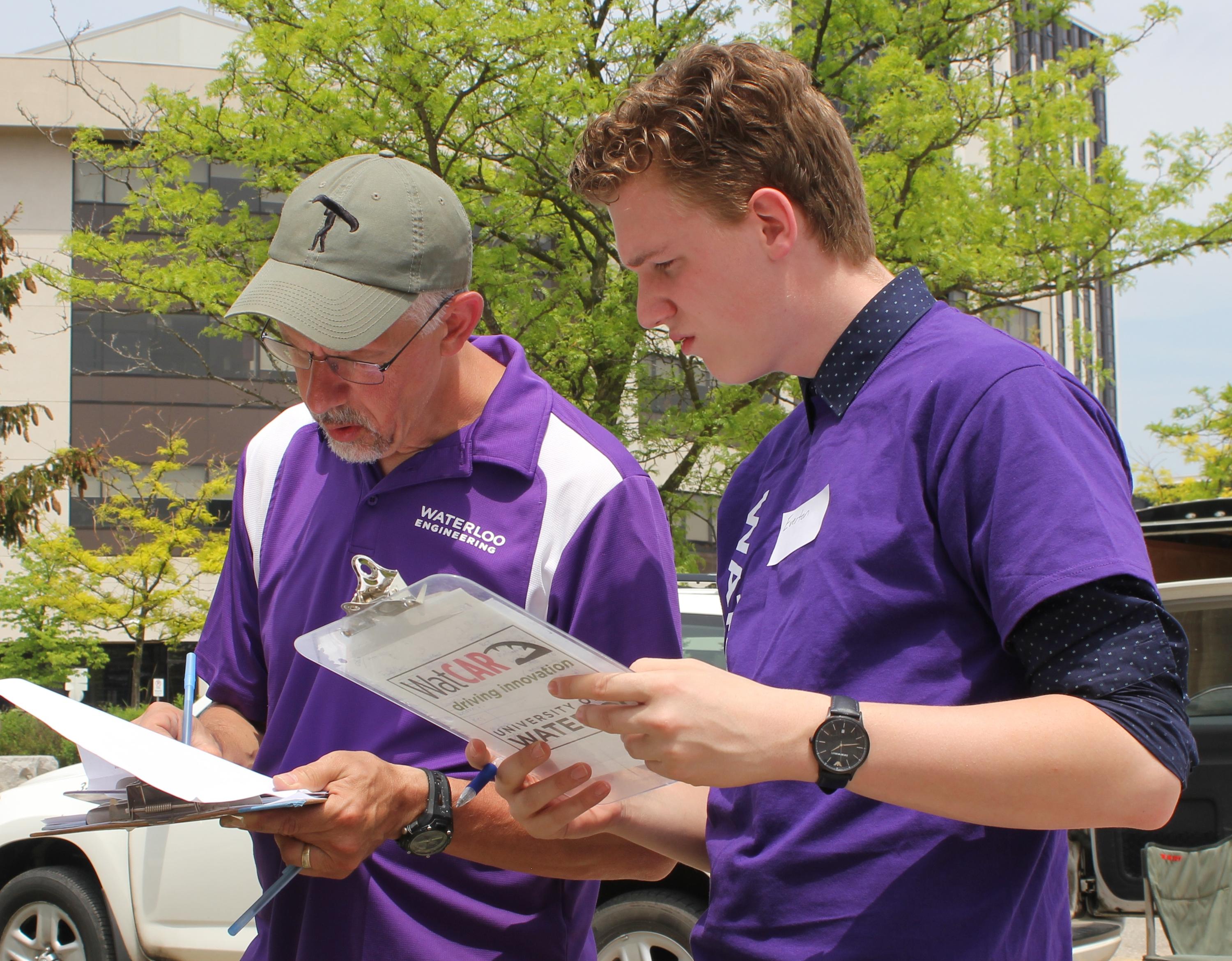 Race organizer Peter Teertstra, left, and student volunteer Everton Dimeck tabulate the results Saturday at the Waterloo Electric Vehicle Challenge.