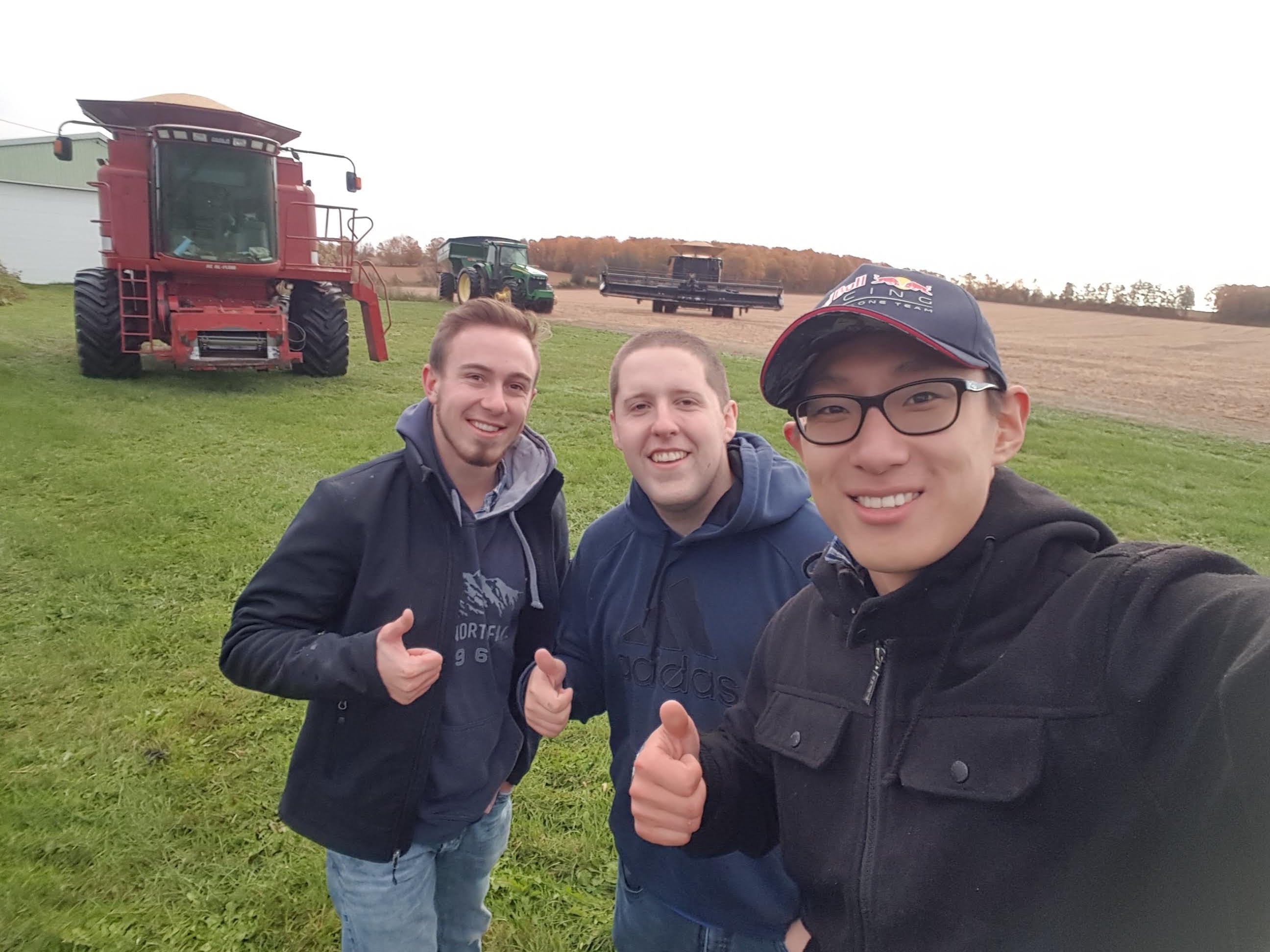Three males in field with tractor