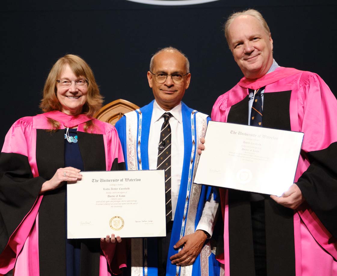 Linda Archer Cornfield and David J. Cornfield accepting their honorary doctorates on stage with President Vivek Goel at University of Waterloo convocation
