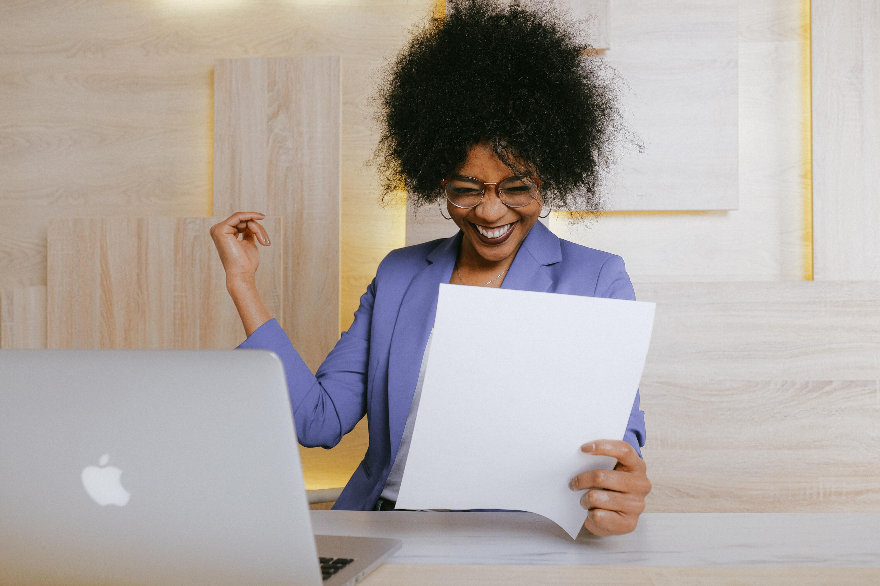 Woman sitting at computer looking excited and happy